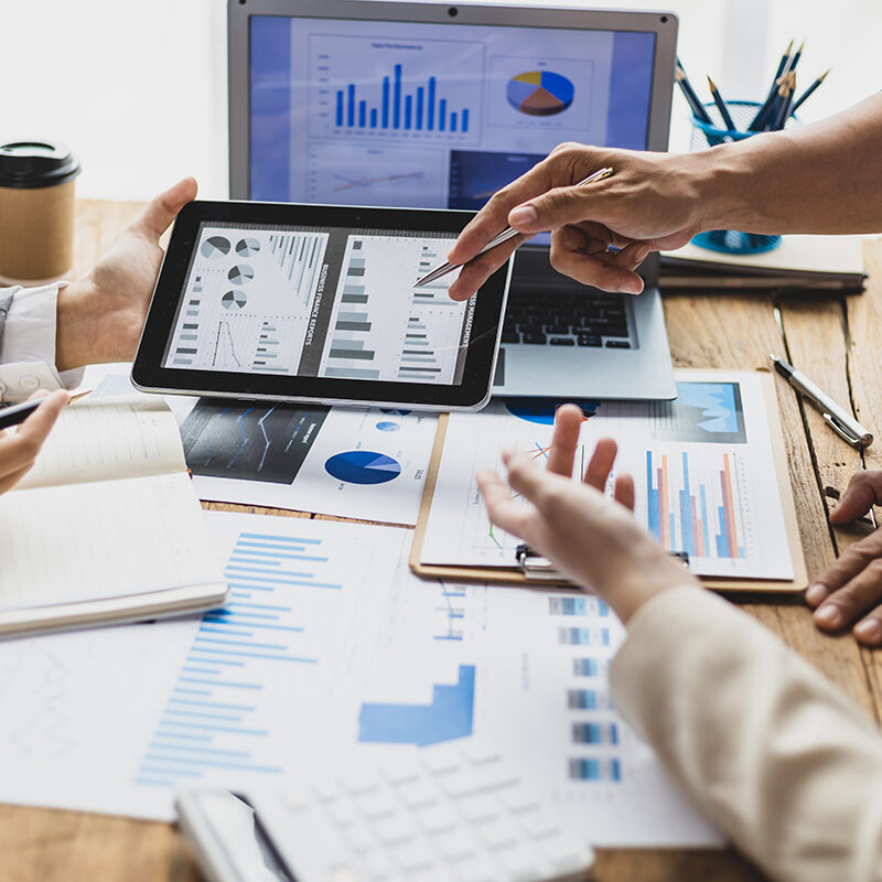 Business people discuss marketing growth chart and make business plan. Business meeting, financial consultants brainstorm analysis of statistical charts in financial reporting documents.